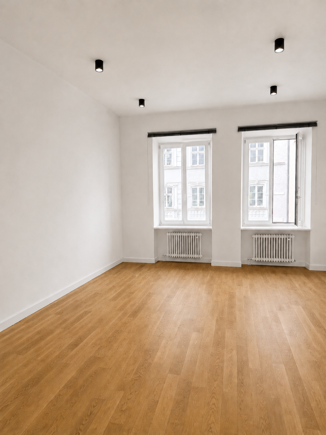 Lichtdurchflutetes Behandlungszimmer mit zwei großen Fenstern
