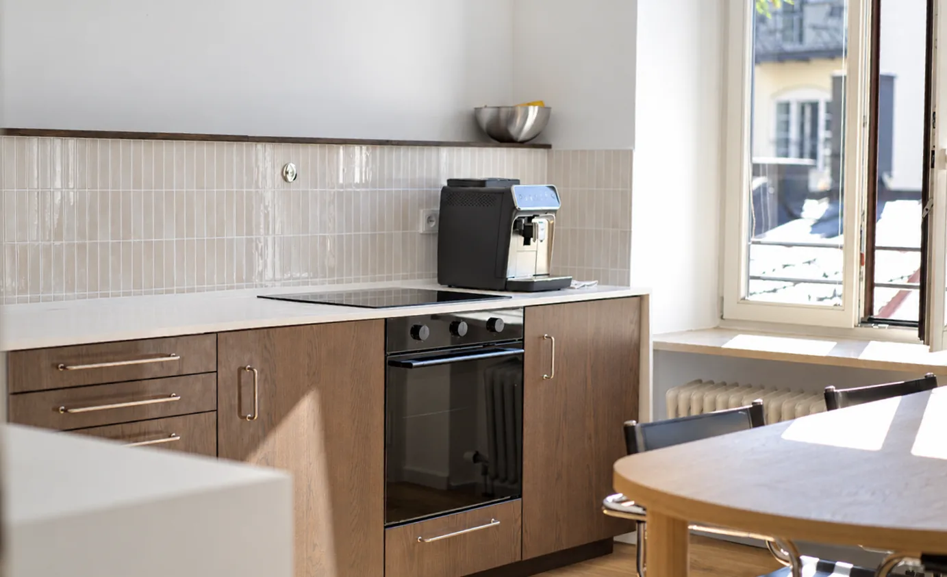 Sonnige Praxisküche mit Holzfronten und Kaffeemaschine