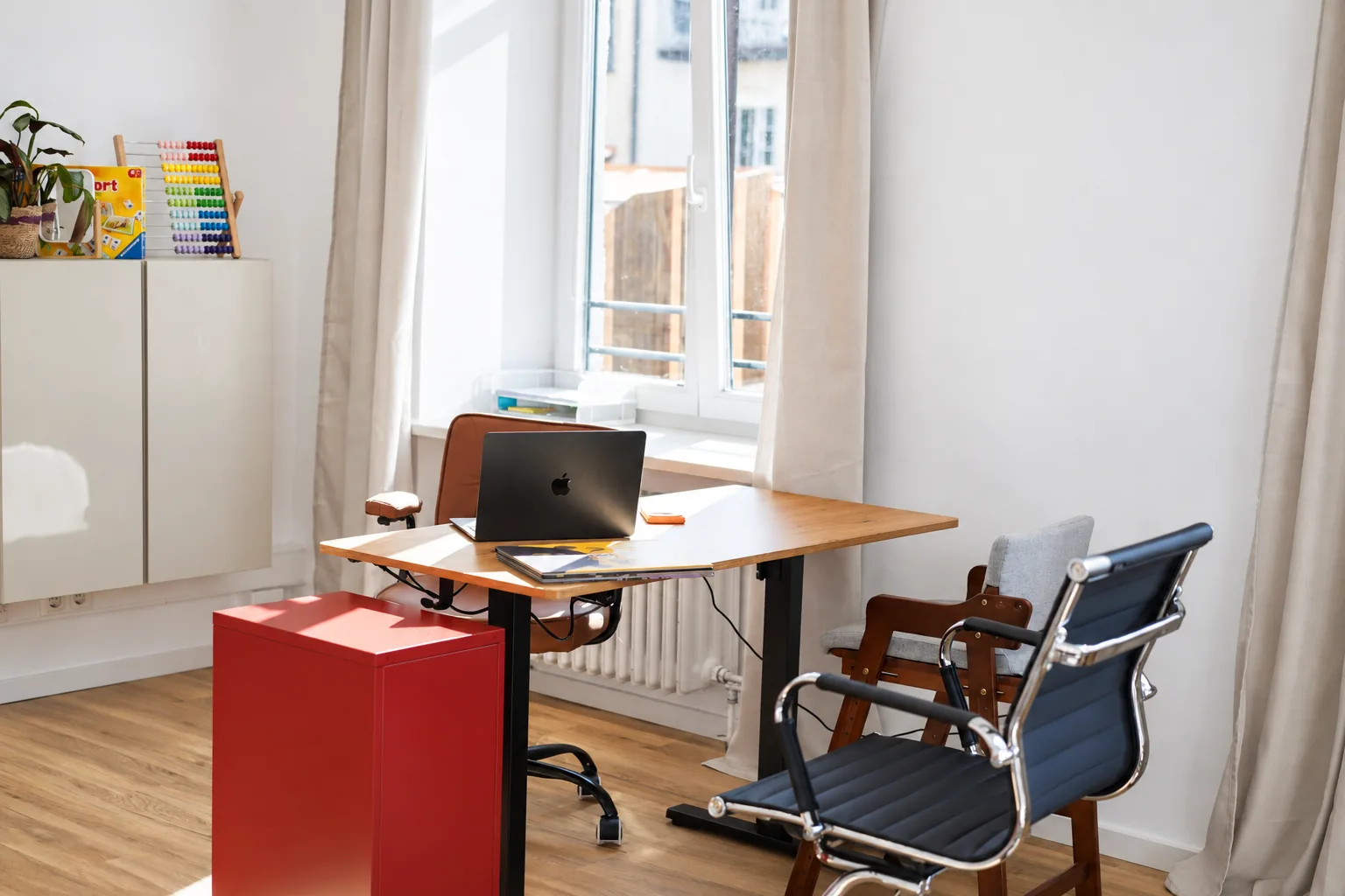 Behandlungszimmer mit Schreibtisch am Fenster und Laptop