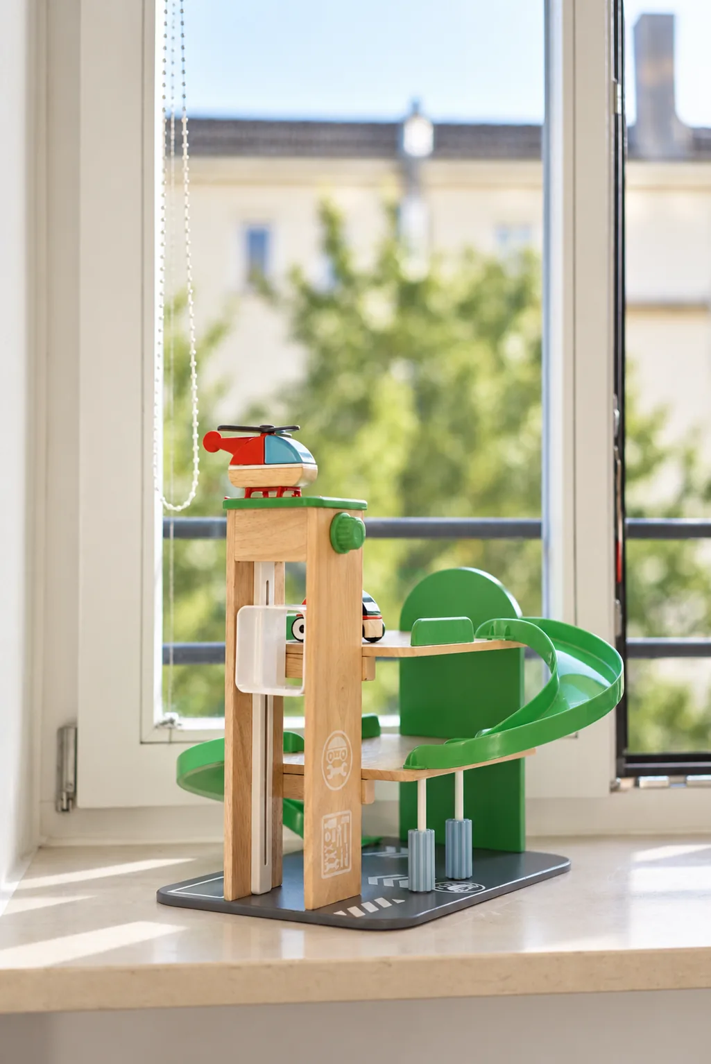 Spielzeug-Parkhaus aus Holz auf der Fensterbank